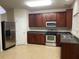 Well-lit kitchen featuring stainless steel appliances, ample cabinets, and neutral tile floors, ready for cooking at 21 Suncrest Ct, Durham, NC 27703