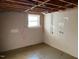Unfinished basement with painted concrete walls, and a small window at 2117 George Winston Rd, Oxford, NC 27565