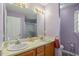 Well-lit bathroom with double sinks, a window, and a shower with glass doors at 2152 Haig Point Way, Raleigh, NC 27604