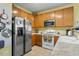 Functional kitchen with wooden cabinets, stainless steel refrigerator and white appliances at 2152 Haig Point Way, Raleigh, NC 27604