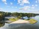 Scenic aerial view of a waterfront recreational area featuring a blue community center, a beach, and parking at 220 Choctaw Dr, Louisburg, NC 27549
