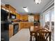 An eat-in kitchen with oak cabinets, black appliances and view to the outdoor deck at 220 Choctaw Dr, Louisburg, NC 27549
