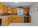 An eat-in kitchen with oak cabinets and black appliances at 220 Choctaw Dr, Louisburg, NC 27549
