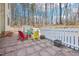 Paver patio with colorful chairs, a white picket fence, and wooded views at 2431 Winburn Ave, Durham, NC 27704
