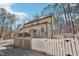Rear exterior of home, featuring a large wooden deck and a white picket fence for added privacy and charm at 2431 Winburn Ave, Durham, NC 27704