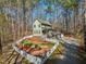 Aerial view of a home surrounded by tall trees with a well-maintained yard, white picket fence and a gravel driveway at 2431 Winburn Ave, Durham, NC 27704