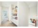 Bright hallway featuring built-in shelving, white trim, and neutral carpet at 2431 Winburn Ave, Durham, NC 27704