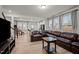 Cozy living room with large windows, hardwood floors, and comfortable leather sofa at 3015 Cypress Lagoon Ct, Durham, NC 27703