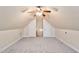 Spacious attic with neutral carpet, a ceiling fan, and two storage doors at 3112 Gold Dust Ln, Willow Springs, NC 27592