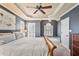 Beautiful main bedroom showcases a tray ceiling, chandelier, and two large windows with bright natural light at 3112 Gold Dust Ln, Willow Springs, NC 27592