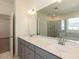 Bathroom featuring a double sink vanity with gray cabinets, quartz countertop, and large mirror reflecting the shower at 3354 Brunot St, New Hill, NC 27562