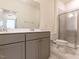 Modern bathroom featuring a double vanity with gray cabinets and a glass-enclosed shower at 3354 Brunot St, New Hill, NC 27562