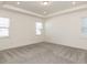 Bright, carpeted bedroom with tray ceiling and windows on opposite walls at 3354 Brunot St, New Hill, NC 27562
