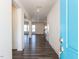 Inviting entryway with a light blue front door and pristine hardwood floors and white walls at 3354 Brunot St, New Hill, NC 27562
