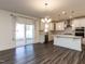 Modern kitchen features white cabinets, stainless steel appliances, and pendant lighting over island at 3354 Brunot St, New Hill, NC 27562