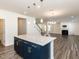 Kitchen island with quartz countertop, dark blue cabinets with gold pulls and pendant lights at 3354 Brunot St, New Hill, NC 27562
