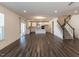 Spacious living room flowing into a kitchen with white cabinets and island, plus a staircase at 3354 Brunot St, New Hill, NC 27562