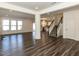 Open-concept living room with hardwood floors, fireplace, staircase and seamless flow to the kitchen at 3354 Brunot St, New Hill, NC 27562