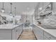 Open-concept kitchen featuring gray cabinetry, island, stainless steel appliances, and hardwood flooring at 3381 Lovage Dr, Apex, NC 27502
