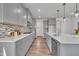 Bright kitchen featuring gray cabinetry, stainless steel appliances, mosaic backsplash, and hardwood flooring at 3381 Lovage Dr, Apex, NC 27502
