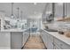 Open-concept kitchen featuring gray cabinetry, island, stainless steel appliances, and hardwood flooring at 3381 Lovage Dr, Apex, NC 27502