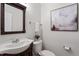 Well-lit half bath featuring a dark wood vanity and neutral color scheme at 3439 Archdale Dr, Raleigh, NC 27614