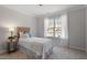 Cozy bedroom with a textured headboard and sun-filled window at 3439 Archdale Dr, Raleigh, NC 27614