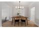 Elegant dining room with modern lighting fixture, a wooden table with seating for four, and neutral walls at 3439 Archdale Dr, Raleigh, NC 27614