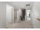 Bright hallway with neutral carpet and fresh paint, leading to additional rooms and staircase at 3439 Archdale Dr, Raleigh, NC 27614