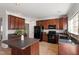 Open-concept kitchen featuring dark wood cabinets, stainless steel appliances, and a center island at 3439 Archdale Dr, Raleigh, NC 27614