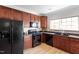 This kitchen features dark appliances with dark wood cabinets, plus a bright window over the sink at 3439 Archdale Dr, Raleigh, NC 27614