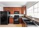 Bright kitchen with dark appliances and dark wood cabinetry is displayed with a window over the sink at 3439 Archdale Dr, Raleigh, NC 27614