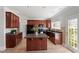 Well-lit kitchen boasts dark wood cabinetry, laminate floors, a center island, and stainless steel appliances at 3439 Archdale Dr, Raleigh, NC 27614