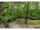 Landscaped backyard patio featuring mature trees, lush plants, and scenic outdoor space at 3604 Pasture Rd, Hillsborough, NC 27278