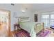 Bedroom with wood floors, a gold bed frame, and a view of the outside at 3604 Pasture Rd, Hillsborough, NC 27278