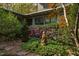 Exterior view features a serene garden with lush greenery, flowering bushes, and a stone statue at 3604 Pasture Rd, Hillsborough, NC 27278