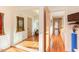 Hallway featuring hardwood floors, natural light, and a glimpse into a home gym at 3604 Pasture Rd, Hillsborough, NC 27278