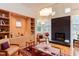 Bright living room features hardwood floors, fireplace, built-in shelves, and many windows at 3604 Pasture Rd, Hillsborough, NC 27278