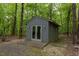 Exterior view shows the outbuilding, surrounded by mature trees, enhancing the property's functionality at 3604 Pasture Rd, Hillsborough, NC 27278
