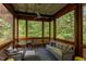 Screened porch with seating area and wooded views offering a tranquil outdoor living space at 3604 Pasture Rd, Hillsborough, NC 27278