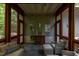 Enclosed porch with curated design, ample seating, and views of greenery enhancing the home's charm at 3604 Pasture Rd, Hillsborough, NC 27278