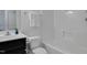 Bright bathroom features a vanity with black cabinets and a shower-tub combo at 3924 Volkswalk Pl, Raleigh, NC 27610
