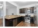 Modern kitchen with dark cabinetry, stainless steel appliances, and granite countertops at 3924 Volkswalk Pl, Raleigh, NC 27610