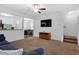 Open concept living area with a tv, stairs to the upper level, and an adjacent kitchen area at 3924 Volkswalk Pl, Raleigh, NC 27610