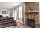 Comfortable living room featuring a stone fireplace, leather sofa, and natural light at 4014 Peeler Ct, Rolesville, NC 27571