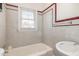 Bright bathroom featuring a tub and tiled walls, complemented by a window for natural light at 410 E Mcneill St, Lillington, NC 27546
