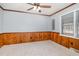 Bedroom featuring wood paneling, carpeted floors, ceiling fan, and natural light at 410 E Mcneill St, Lillington, NC 27546