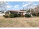 Charming exterior view of the home, featuring lush landscaping, a red roof, and mature trees at 410 E Mcneill St, Lillington, NC 27546