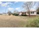 Front yard view of the home with a red roof, mature trees, and well-maintained landscaping at 410 E Mcneill St, Lillington, NC 27546