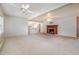 Open living room with a fireplace, ceiling fans, and views of the connected kitchen, providing a spacious feel at 410 E Mcneill St, Lillington, NC 27546